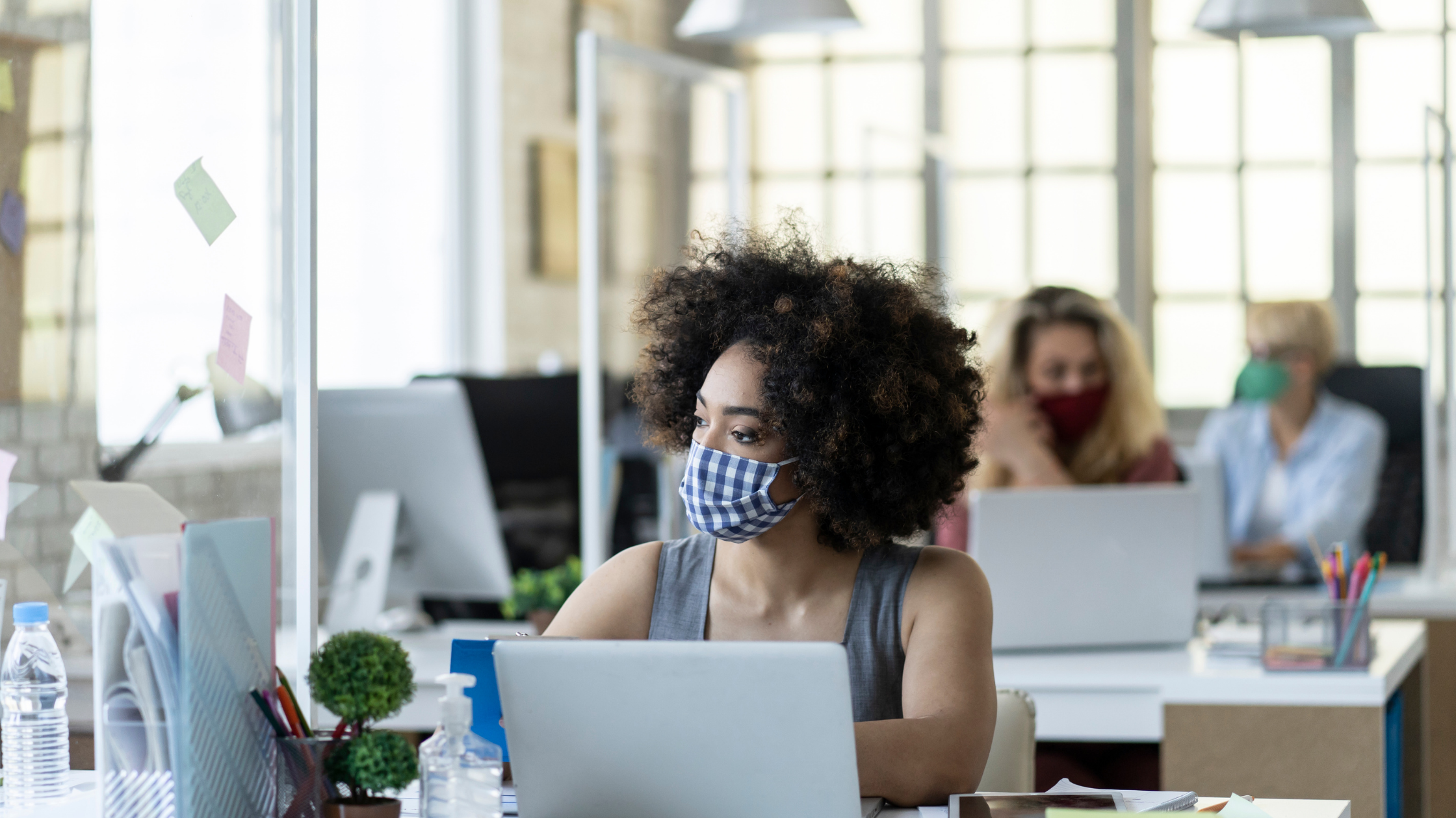 Woman at desk in office wearing a mask